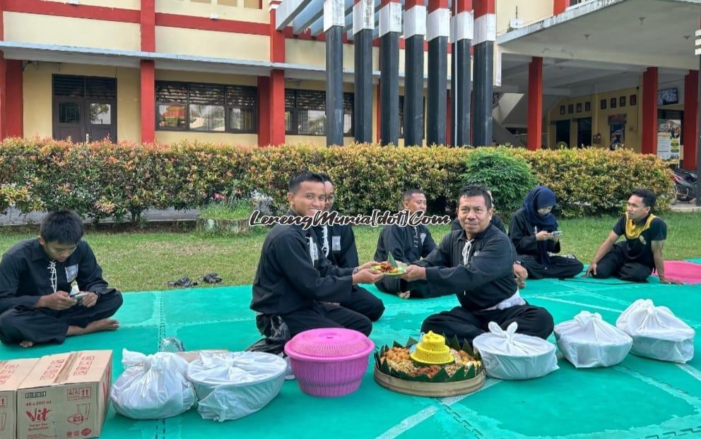 Wisnu Tri Pamungkas (kiri) sebagai Ketua SH Terate Komisariat SMAN 3 Pati menerima potongan tumpeng dari Eko Wahono (kanan) selaku pembina komisariat