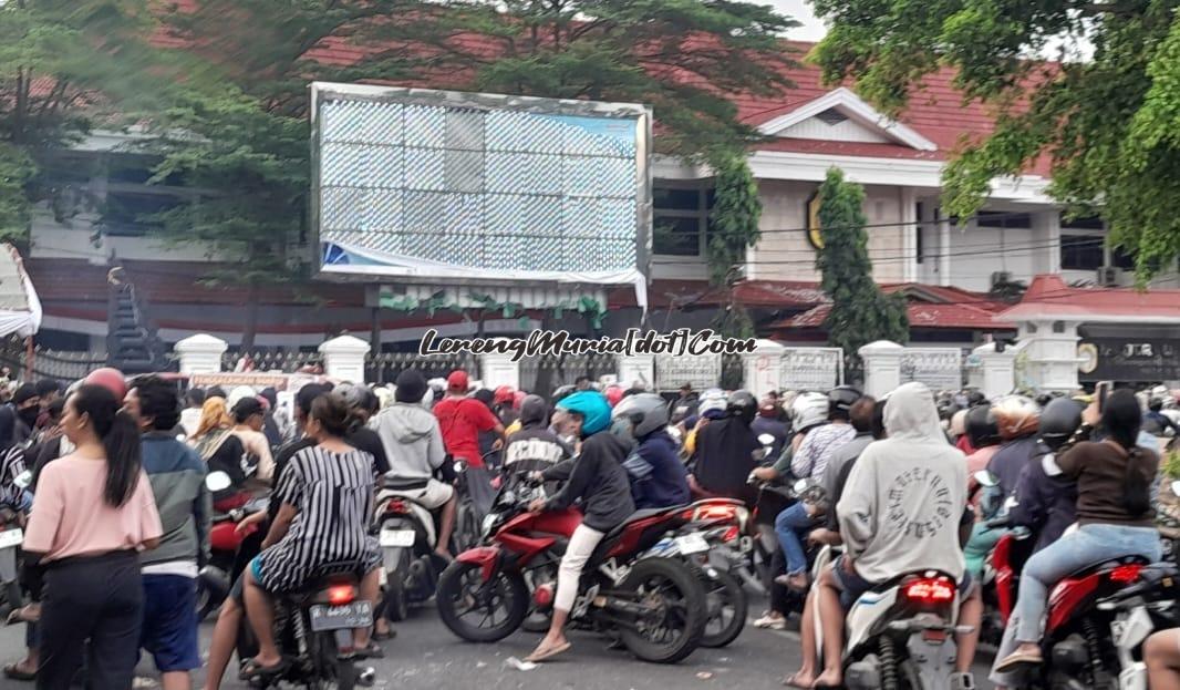 Warga Pati menyaksikan sisa kardus minuman dan sampah bekas demonstrasi di depan Pendopo Kabupaten Pati