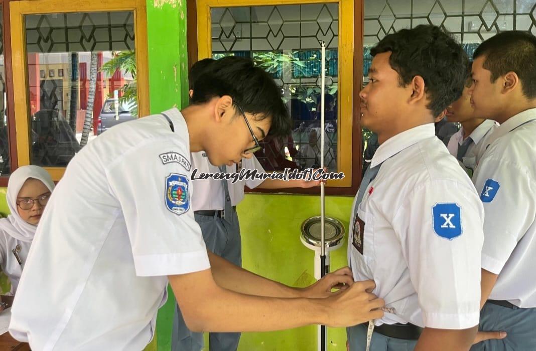 Anggota PMR SMAN 3 Pati  sedang mengukur lingkar perut temannya
