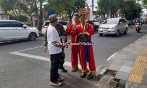 Dua pesilat Tapak Suci Kabupaten Pati ikut membantu menyeberangkan peserta jalan sehat HUT Guru ke 80 dan HUT IGI ke 16