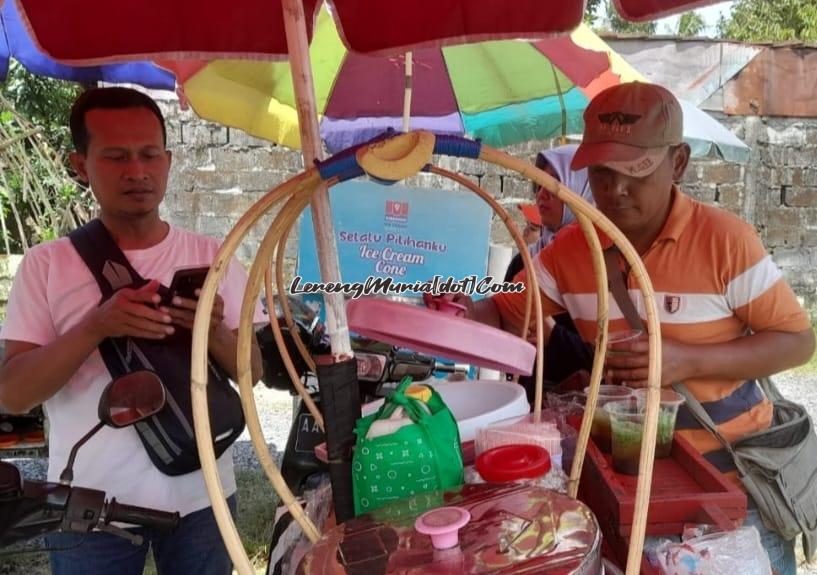 Mas Eddi (kanan) penjual es dawet ayu Banjarnegara sedang melayani pembeli