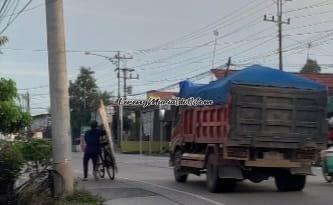 Penjual gedek bersepeda melewati Jalan Raya Purwodadi-Blora Kelurahan Punggursugih Kecamatan Ngawen Blora