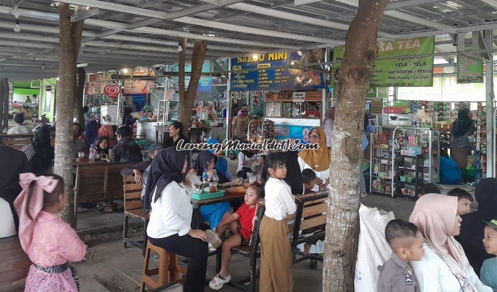 Para pengunjung duduk santai sambil menikmati aneka kuliner yang murah meriah di lokasi wisata