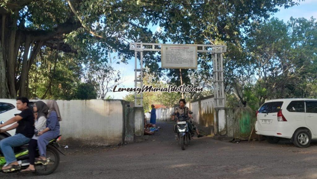 Warga Desa Puri keluar dari pintu masuk TPU Puri setelah melakukan ziarah kubur