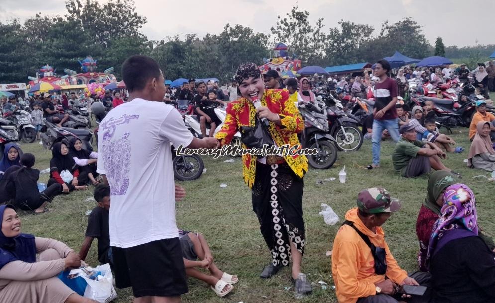 Seorang penonton sedang nyawer dagelan Dodok yang ada di sekitar panggung kethoprak